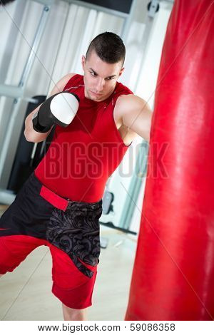 young muscular boxer punching bag