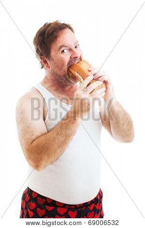 Middle aged man in his underwear, stuffing his face with a giant hoagie sandwich.  Isolated on white.  