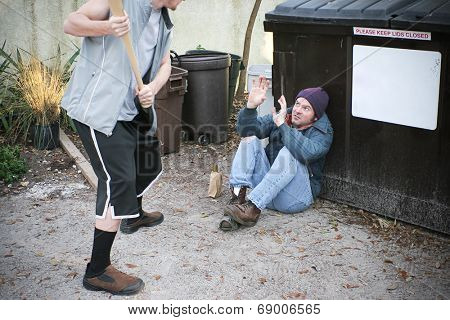 Young thug male threatening to beat a homeless man with a baseball bat.  