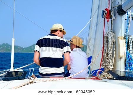 Back view of father and son sailing on a luxury yacht or catamaran boat