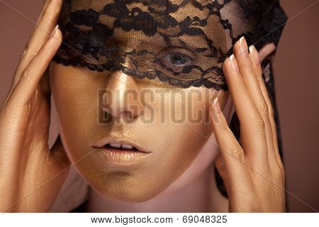 Woman With Gold Make Up And Lace On Face