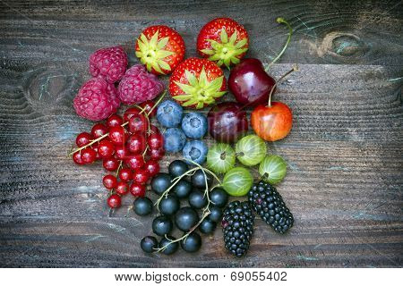 Summer wild berry fruits on vintage board