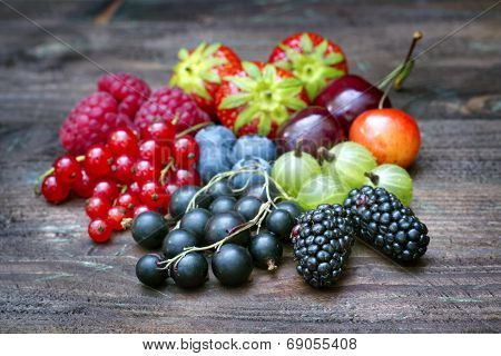 Summer wild berry fruits on vintage board