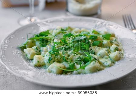 Gnocchi with cheese sauce, spring spinach and arugula