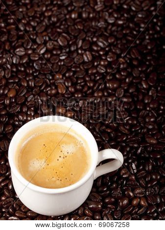 Fresh Cup Of Dark Roasted Coffee With Coffeebeans In The Background