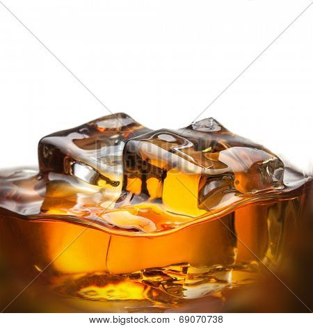 Splash of whiskey with ice in glass isolated on white background