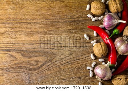 Pepper, garlic and walnuts on a wooden board