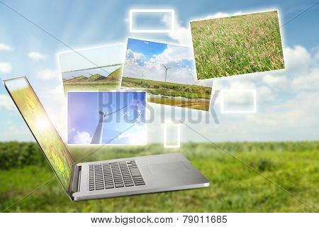 Laptop and images of nature on field and sky background