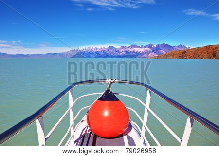 Excursion on the tourist boat on Lake Viedma.  White-blue huge icebergs float near a ship board. Ice and sun Patagonia