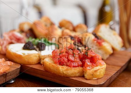 Italian appetizers on wooden plank, close-up