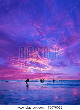 Silhouettes of people at sunset on the beach of Kuta Bali Indonesia