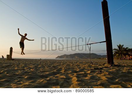 Unidentified man balancing on slackline at a beach in Manabi, Ecuador