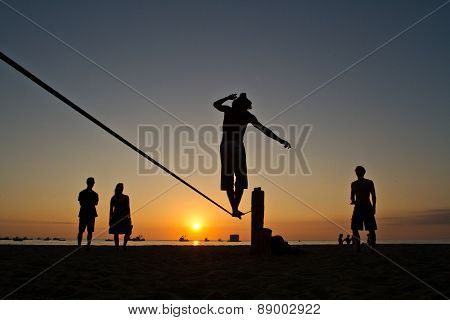 Silhouette of young man balancing on slackline at a beach in Manabi, Ecuador