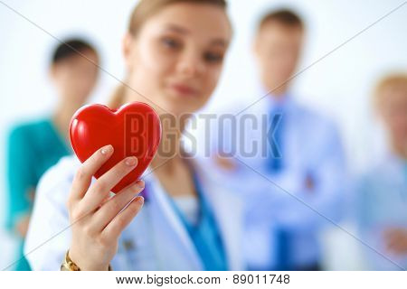 Female doctor with stethoscope holding heart .