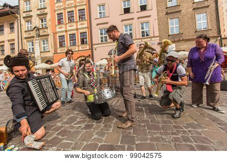 KRAKOW, POLAND - JUL 12, 2015: Participants at the annually (July 9-12) 28th International Festival of Street Theatres - Orchestre International du Vetex (Belgium/France) in the Main Square of Krakow.