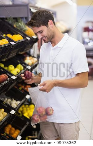 Smiling hansome buying a fruits at supermarket