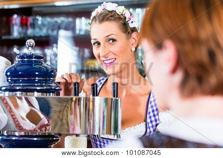 Innkeeper in Bavarian pub with customers