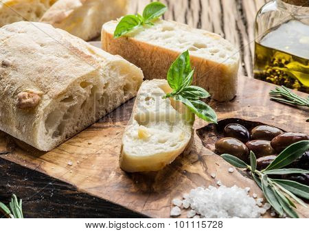 Ciabatta, olives and blue cheese on the wood.