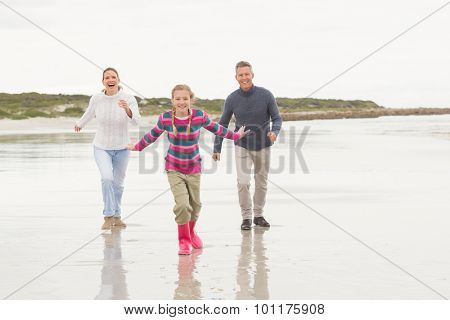 Parents chasing their kid for fun at the beach