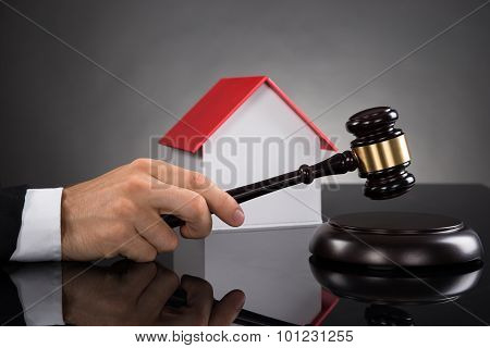 Judge With House Model Hitting Gavel