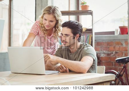 Man and woman working on laptop in creative brigth office