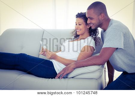 Young couple with sonogram on sofa at home