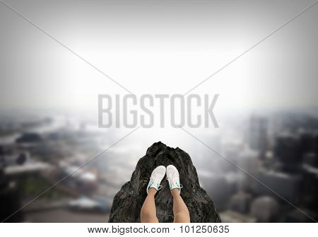 Close up of woman legs standing on the edge of rock