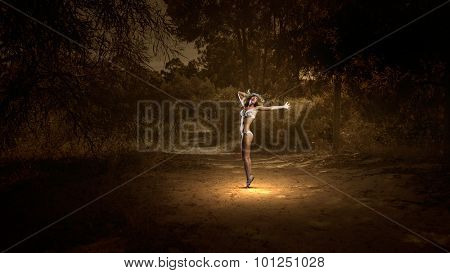 Hot young dancing woman in white bikini on dark background