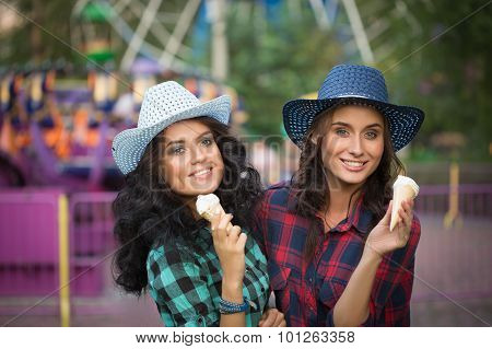 two beautiful girls in cowboy hats eating ice cream