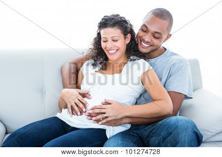 Young couple enjoying sitting on sofa at home