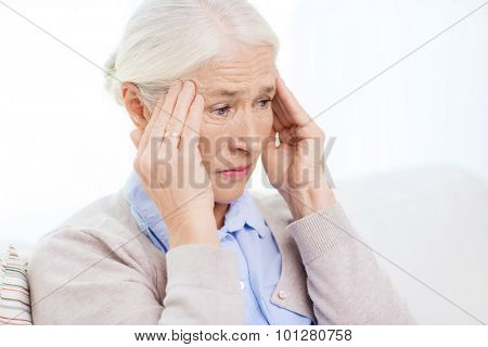 health care, pain, stress, age and people concept - face of senior woman suffering from headache