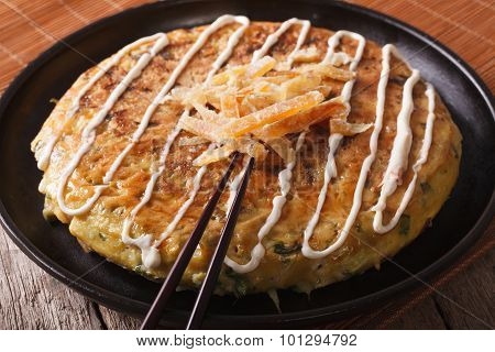 Japanese Fast Food: Okonomiyaki Close-up And Chopsticks. Horizontal