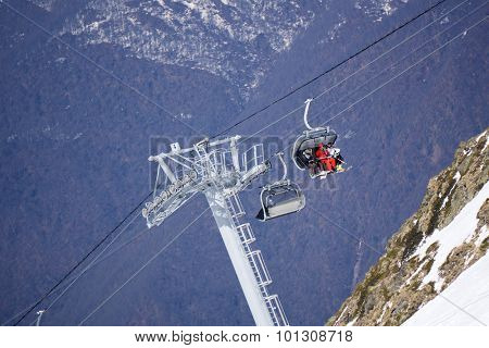 Skiers and snowboarders on a mountain ski lift