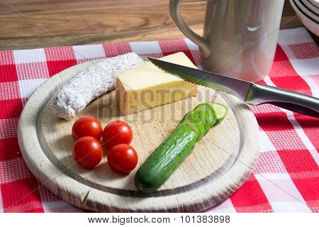 a snack with cheese, tomatoes, cucumber and salami