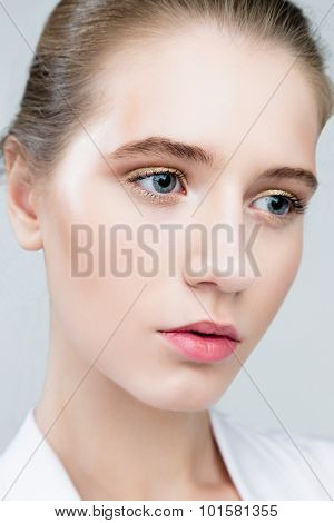 Beautiful Face of Young Woman with Clean Fresh Skin close up isolated on grey.