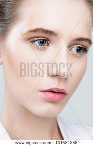Beautiful Face of Young Woman with Clean Fresh Skin close up isolated on grey.