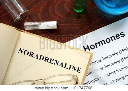 Hormone noradrenaline written on book.