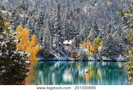 Early snow in Colorado Rocky mountains and mountain reflection in the pond