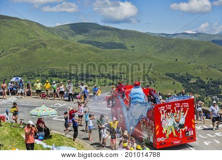 Col de PeyresourdeFrance- July 23 2014: Spectators refreshing under the water spray produced by Vittel vehicle during the passing of the Publicity Caravan on the road to Col de Peyresourde in Pyrenees Mountains in the stage 17 of Le Tour de France 2014.