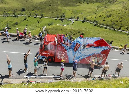 Col de PeyresourdeFrance- July 23 2014: Spectators refreshing under the water spray produced by Vittel vehicle during the passing of the Publicity Caravan on the road to Col de Peyresourde in Pyrenees Mountains in the stage 17 of Le Tour de France 2014