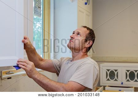 Worker Installing Kitchen Cupboard