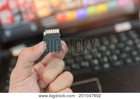 SD card with laptop computer background hand showing