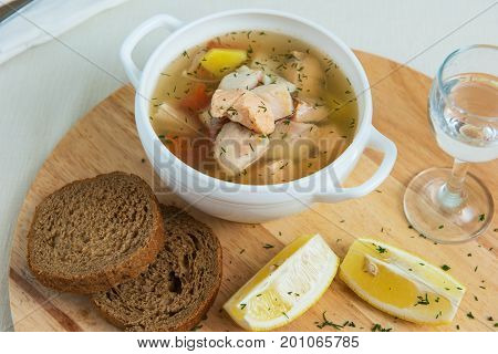 Russian traditional fish soup - ukha, served with bread lemon tomato and vodka