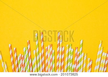 close-up colorful fancy drinking straws fancy tube for party on the yellow background