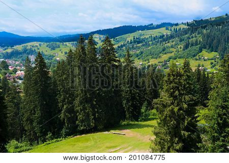 summer view of Carpathian Mountains landscapevillage Vorohta Ukraine. Green forests, hills, grassy meadows and blue sky. View from the ski jump