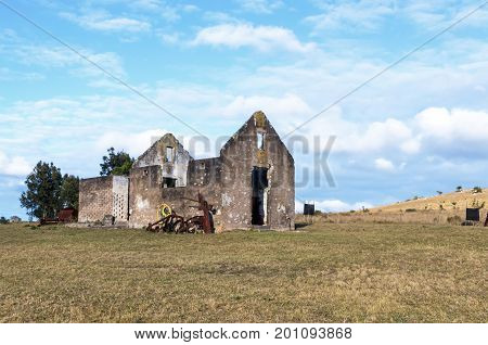 Rural old abandoned derelect farm building on dry winter landscape against blue cloudy sky in Lake Eland Game reserve in South Africa