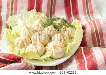 Frozen Dumplings On The White Plate With Green
