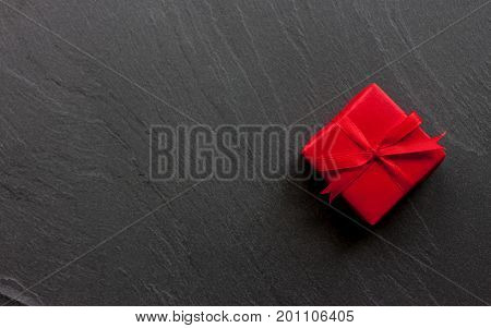 red beautiful wraped gift box on black background