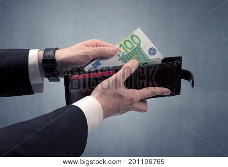 Businessman's hand in suit takes out eruo from his wallet