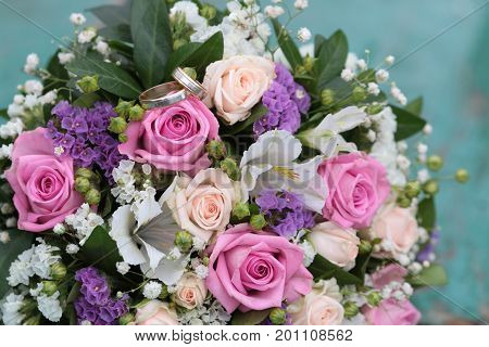 infinity sign of the rings wedding rings on a wood wedding bands wedding rings lie near bouquet of white and pink peach roses a bouquet of roses wedding flowers